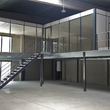Tussenvloer voor kantoor - QV Motors - Magazijnruimte met laaddeur en een kantoorruimte